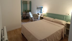 A bedroom with a large bed, a chair, a desk, and a window. - Apartment for four people in nature (Grado)