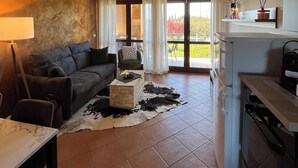 Un soggiorno con divano, tavolino, tavolo da pranzo e angolo cottura.