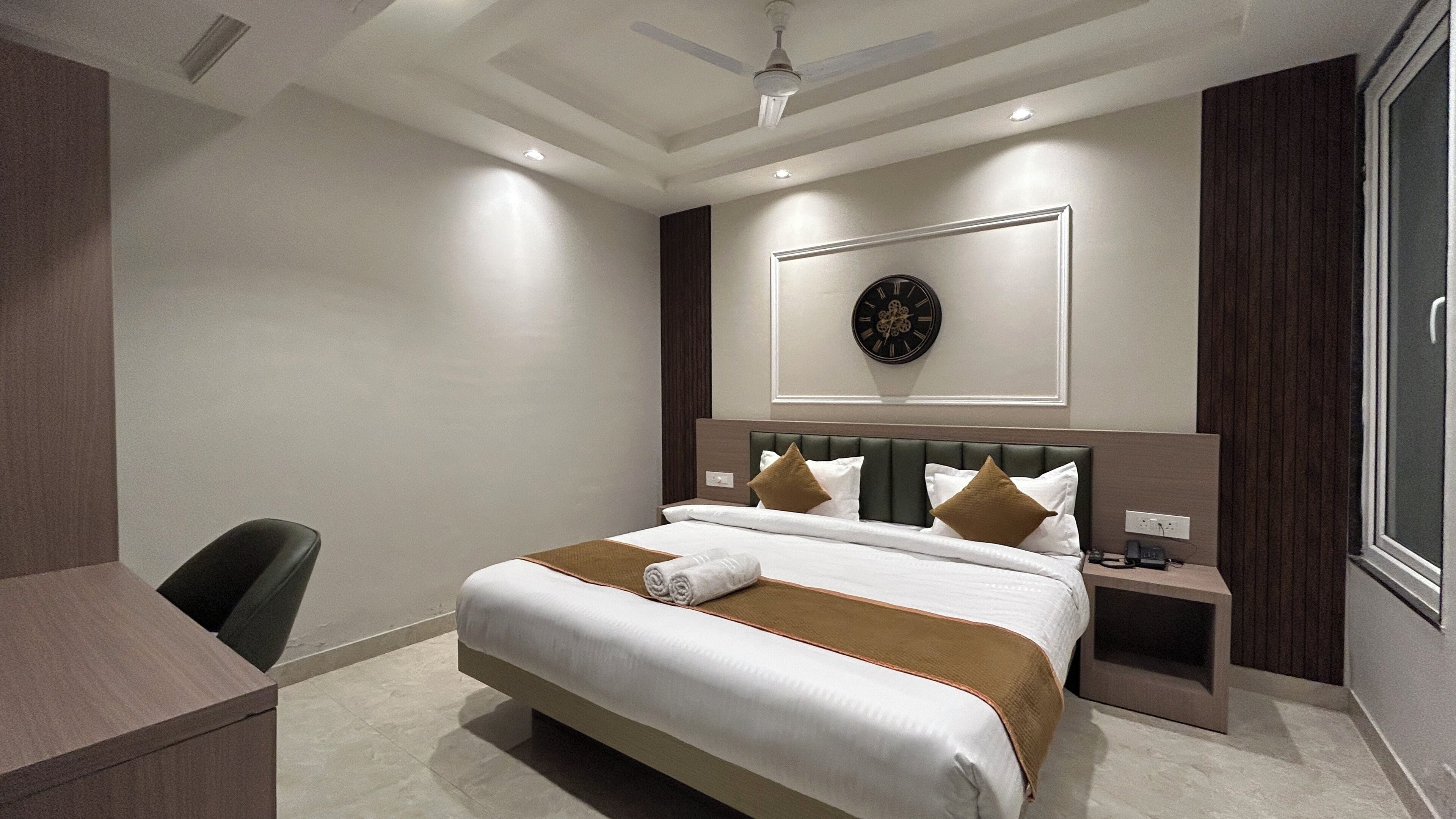 Une chambre d’hôtel moderne avec un grand lit, un bureau et une chaise.