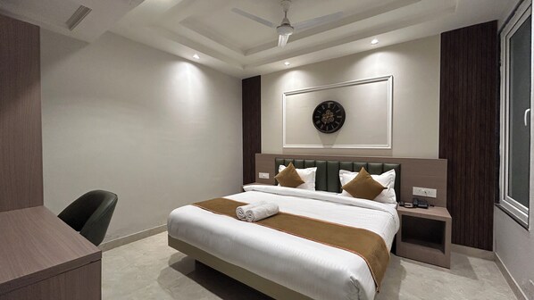 Une chambre d’hôtel moderne avec un grand lit, un bureau et une chaise.
