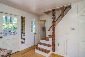 A staircase with wooden steps and a wooden handrail, leading to a second floor.