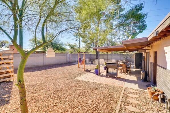 A covered patio area with a barbecue setup, outdoor seating, and a gravel ground. - Half-mi to Loop Access! Private Tucson Hideaway (Tucson)