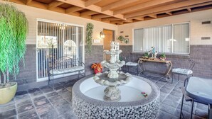 A patio area with a stone fountain, seating, and potted plants. - Half-mi to Loop Access! Private Tucson Hideaway (Tucson)