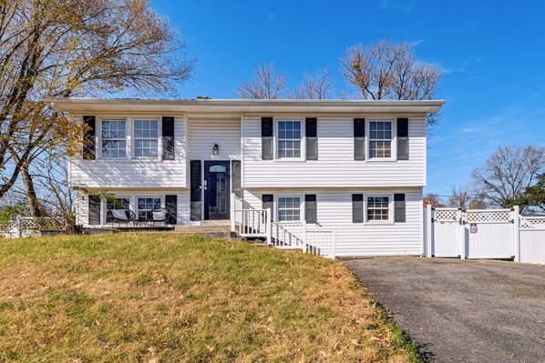 A two-story house with a front porch, a garage, and a gated driveway. - Commute to Alexandria & DC: Home w/ Shared Yard (Waldorf)