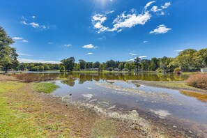 A serene lake with clear water, surrounded by lush greenery and trees. - Lakeside Bungalow at Cedar Pines Lake (Lancaster)