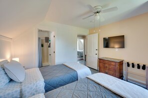 A hotel room with a bed, a TV, a ceiling fan, and a dresser. - Green Mountain Views! Lowell Getaway Near Skiing (Lowell)
