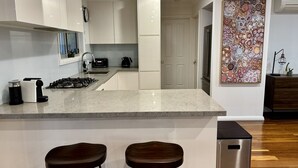Una cucina moderna con un piano di lavoro in marmo, elettrodomestici in acciaio inossidabile e un'ampia finestra.