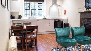 Cocina compacta con comedor, que incluye un ventanal, estufa integrada y radiador.