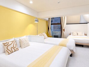 Quarto de hotel com duas camas, uma janela grande com cortinas, um abajur e vista para a cidade.