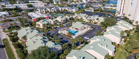 Een luchtfoto van een resort met meerdere gebouwen, een zwembad en een jachthaven.