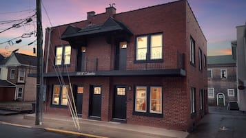 A two-story brick building with a black awning and multiple windows.