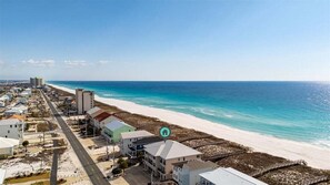A coastal hotel with a beachfront view, a long road leading to the beach, and a pier in the distance. - Seven Sandcastles 4 Bedroom Townhouse (Navarre)