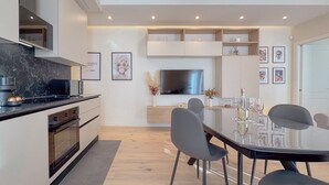 Eine moderne Küche mit Einbauofen, Mikrowelle und einem großen Flachbildfernseher.