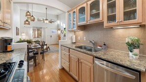 Eine moderne Küche mit Granit-Arbeitsplatten, Edelstahlgeräten und Holzschränken.