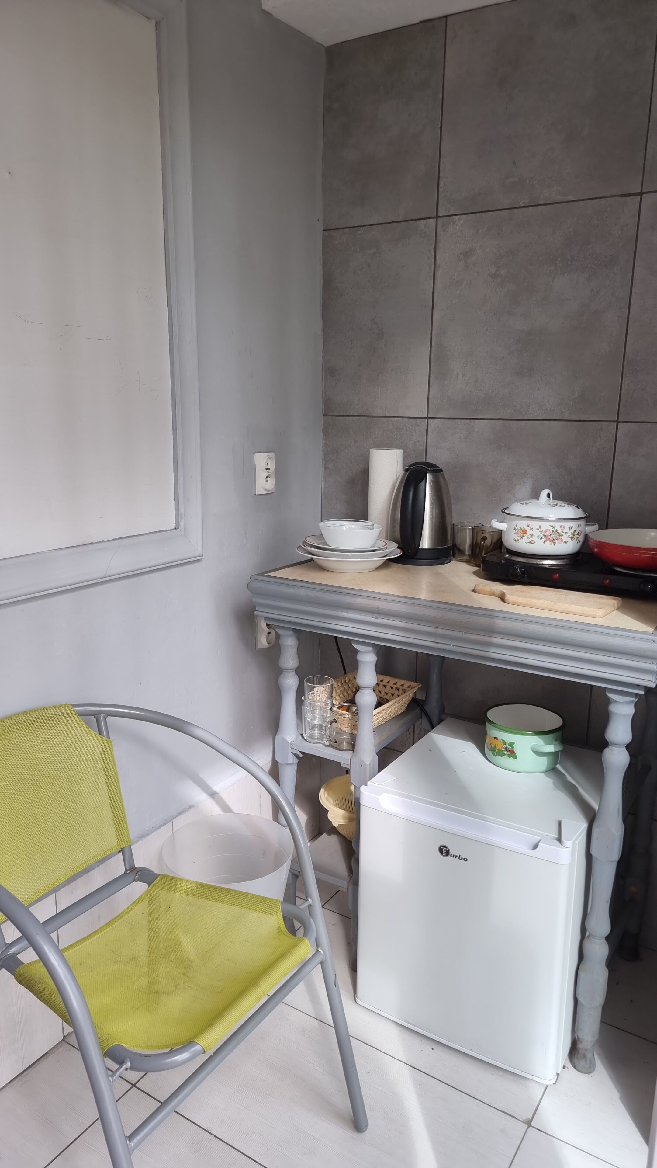 Una cocina con una mesa, sillas, un refrigerador y salpicadero de azulejos.