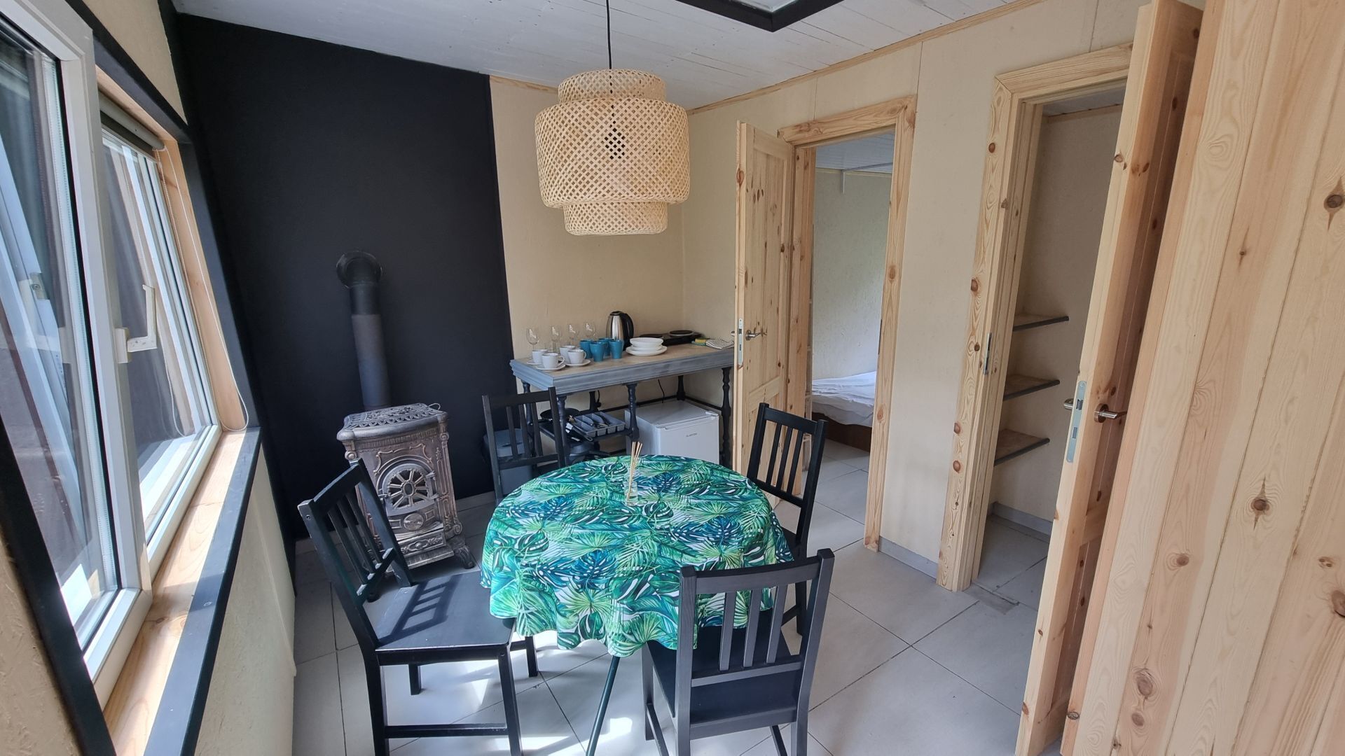 A cozy dining area with a round table, chairs, and a hanging light fixture.