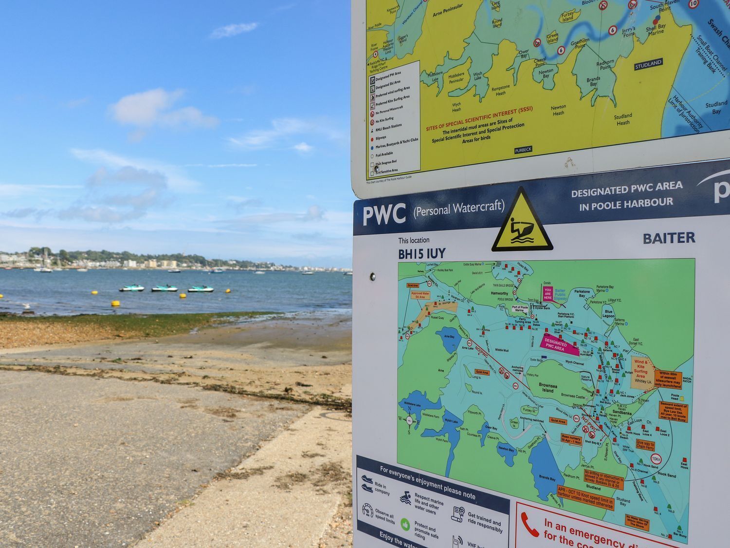 Een kaart van een afgebakend PWC-gebied in Poole Harbour, met daarop aangegeven locaties en een waarschuwingsbord.