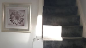 Una escalera con una obra de arte floral enmarcada en la pared.