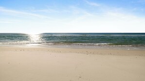 Una playa con cielos despejados y aguas tranquilas.