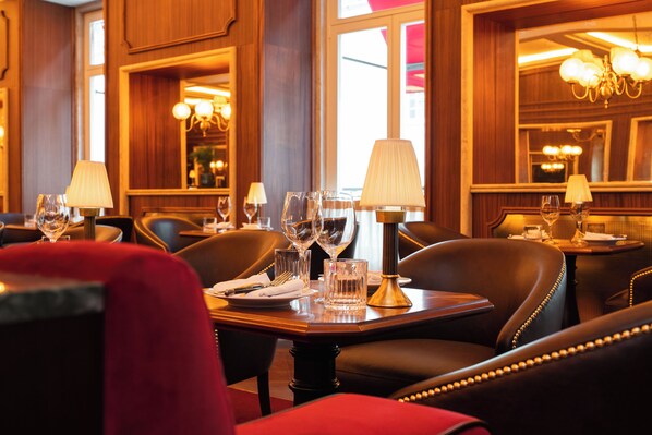 A restaurant interior with wooden paneling, leather chairs, and tables set for dining. - 1904 Benfica Hotel FLH Hotels (Lisbon)