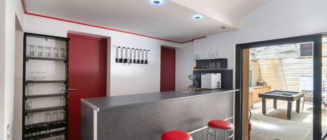 Una cocina moderna con barra, taburetes y vistas al patio exterior.