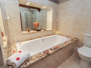 Ein modernes Badezimmer mit einer großen Badewanne, einer Duschkabine aus Glas und einer Toilette.