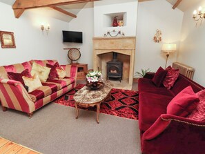 Ein gemütliches Wohnzimmer mit Kamin, zwei Sofas, einem Couchtisch und einem Fernseher.