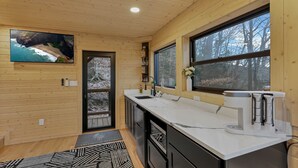 Una cocina moderna con paredes de madera, un ventanal y vistas al exterior.