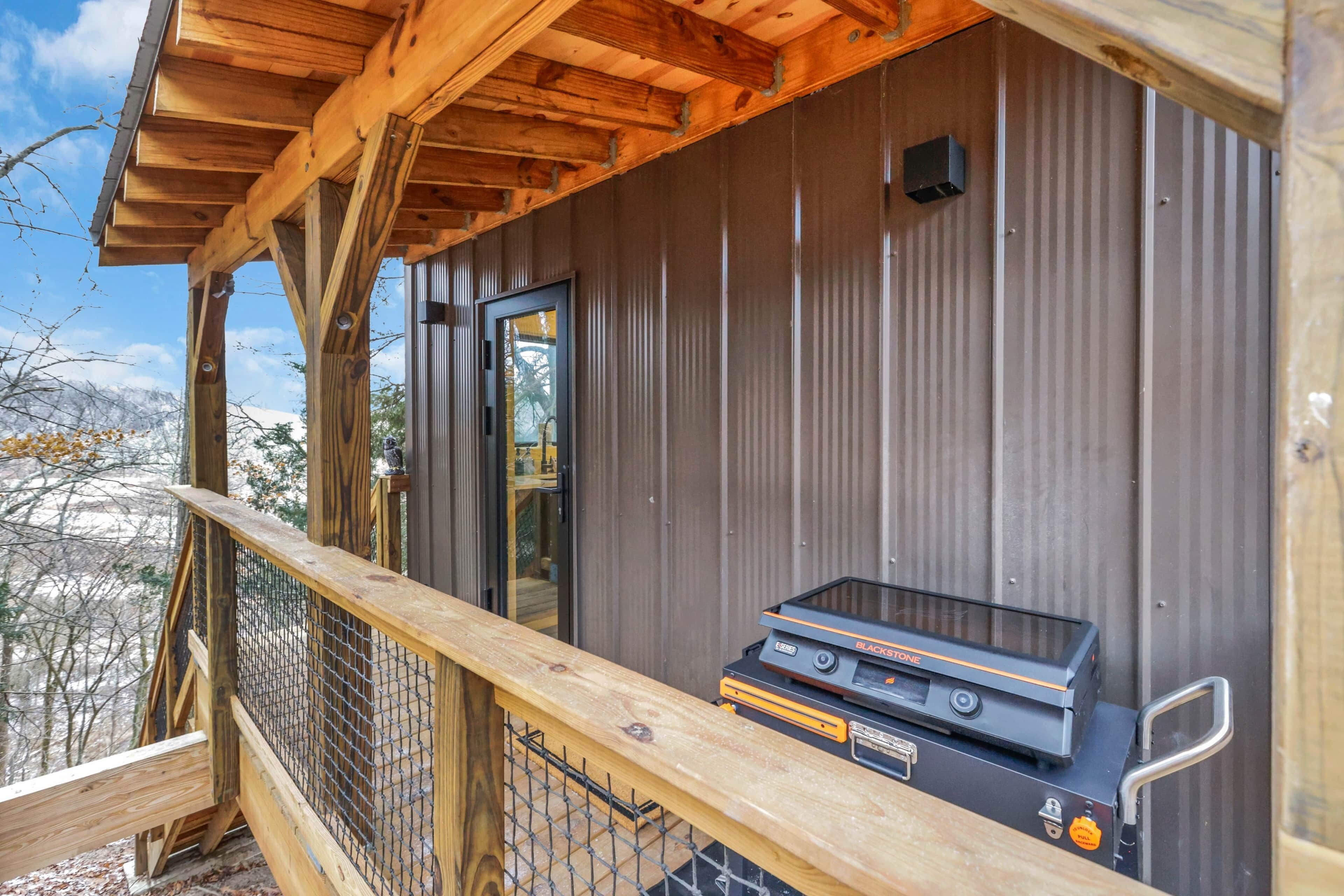 Eine Holzterrasse mit Grill und Metallgeländer.