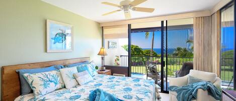 A bedroom with a bed, a ceiling fan, a nightstand, a chair, and a view of the outdoors.