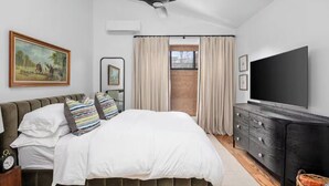 A bedroom with a bed, a ceiling fan, a TV, a dresser, and a window with curtains. - Modern Loft - Parking Included, Walk to Downtown (Lexington)