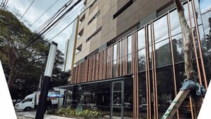 Un bâtiment moderne doté de grandes fenêtres et d’une façade en verre réfléchissant.