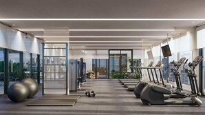 Une salle de sport moderne équipée de tapis de course, de ballons d’exercice et de poids.