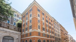 Un edificio de varios pisos con un estilo arquitectónico clásico, que presenta ventanas arqueadas y una fachada simétrica.