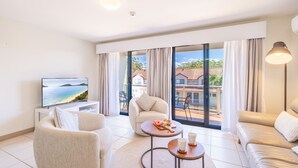 A modern hotel room with a large balcony, a flat-screen TV, and a sofa. - Bay Breeze Apartments, 33   1 Trafalgar St - Aircon, Wi-Fi, Linen, Pool (Nelson Bay)