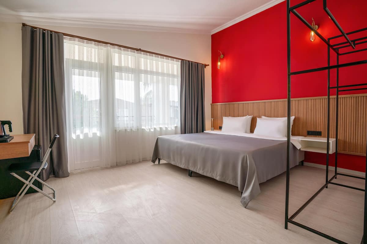 A hotel room with a bed, a desk, and a chair.