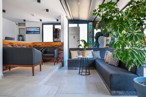 Eine moderne Lobby mit Empfangsschalter, Sitzgelegenheiten und einer großen Pflanze.