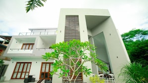 A modern two-story building with a flat roof, large windows, and a central vertical feature. - Stadler Resort (Wadduwa)
