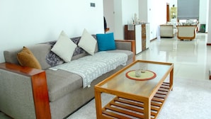 A modern living room with a grey sofa, wooden coffee table, and a small cabinet. - Stadler Resort (Wadduwa)