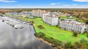 A marina with boats docked, a large hotel with multiple floors, and a well-maintained lawn area. - Barefoot Yacht Club 305-3BR-Near Barefoot Landing (North Myrtle Beach)