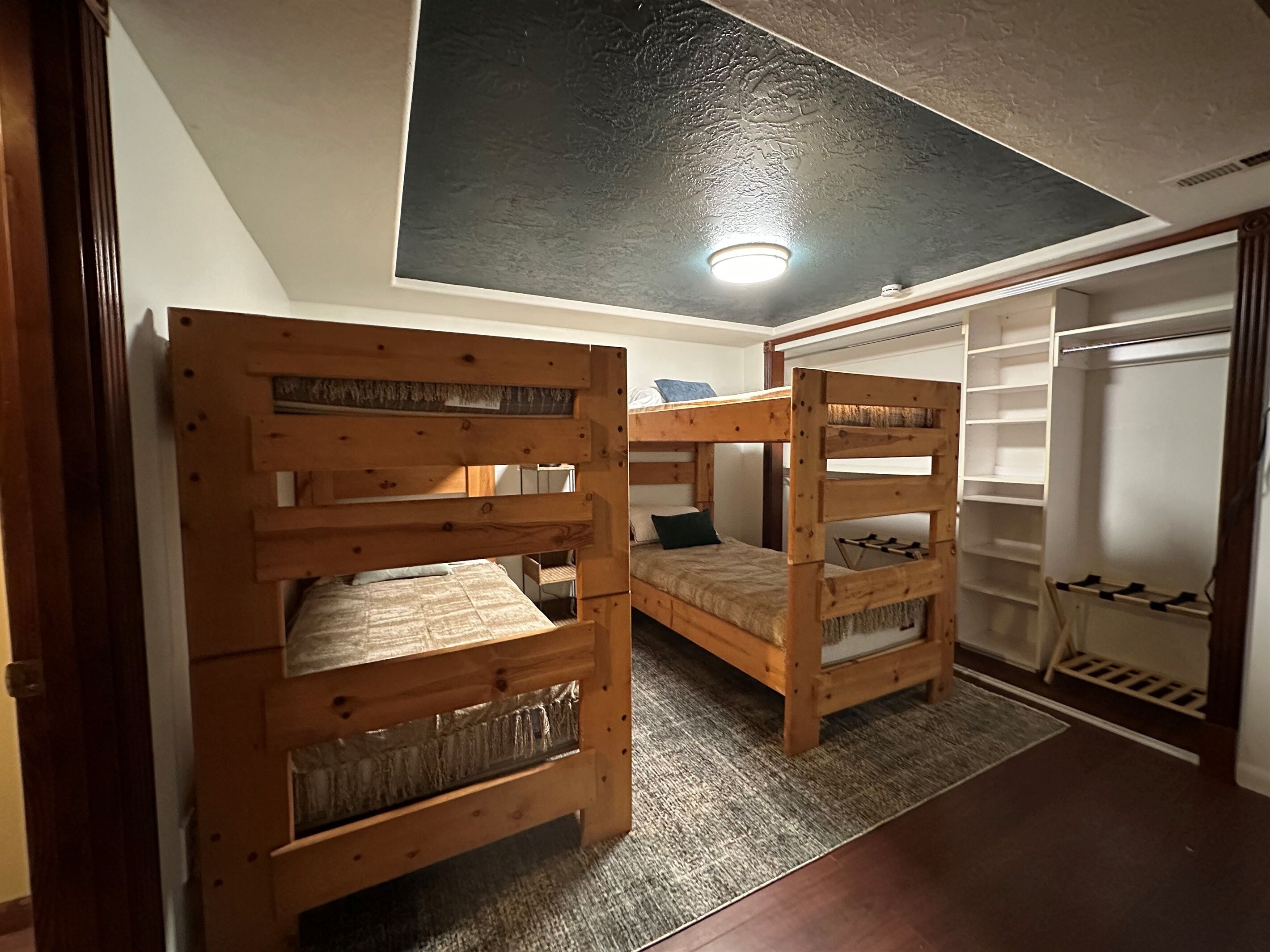 A room with two bunk beds, a walk-in closet, and a ceiling light.
