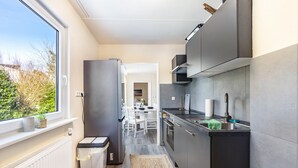 Una cocina moderna con un gran ventanal, horno empotrado y vistas al exterior.