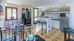 A compact kitchen with a dining area, featuring a refrigerator, microwave, and a small table with chairs. - The property is located in a strategic position: a 7-minute walk from the international barracks, 5 minutes by car from the town center, 5 minutes by car from the hospital, and just 30 seconds from the riverside along the Livenza, perfect for cycling.Ava (Riva Livenza)