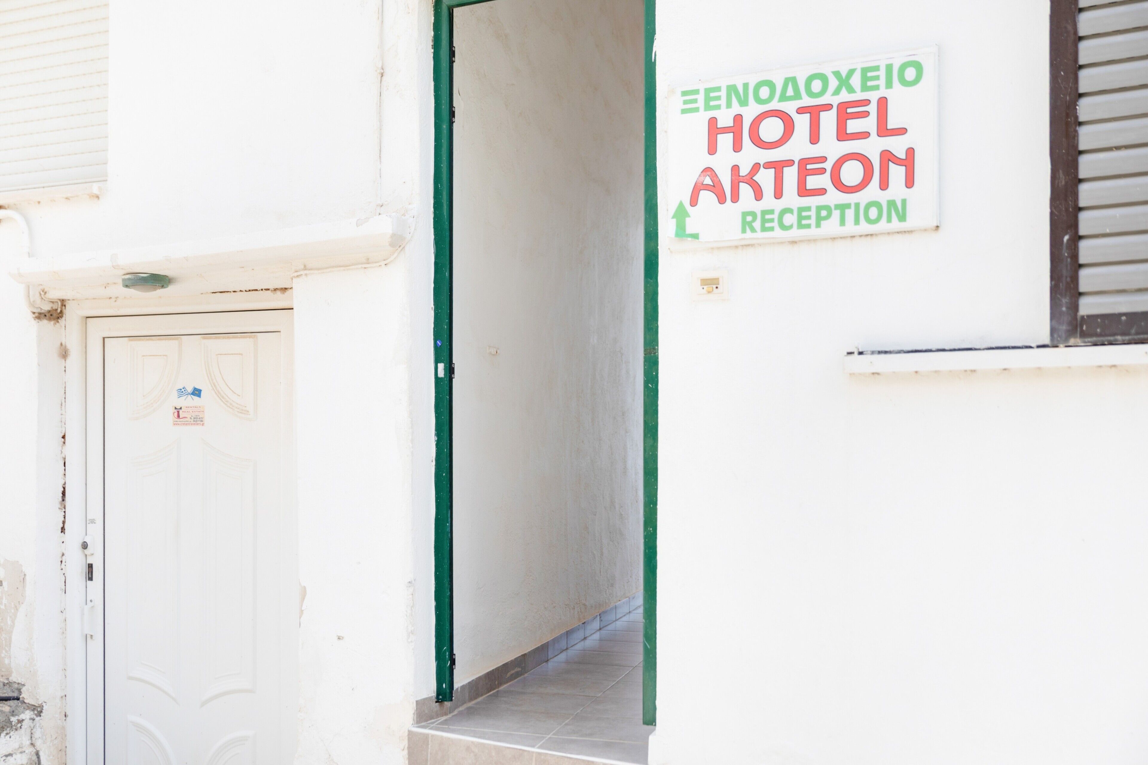 A hotel reception area with a sign indicating the name and direction to the reception.