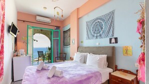 A bedroom with a bed, a nightstand, a desk, a chair, and a view of the sea. - Bed and Breakfast 'Double Room No 101 Sea View' with Sea View, Wi-Fi and Air Conditioning (Crete)