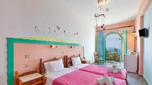 Habitación de hotel con dos camas, un escritorio pequeño, una silla, televisor y balcón con vistas.