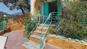 A building with a staircase leading to a door, surrounded by greenery and a clear sky. - Bed and Breakfast 'Double Room No 204 Sea View' with Sea View, Wi-Fi and Air Conditioning (Crete)