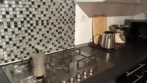 Cuina amb fogó de gas, cafetera i microones.