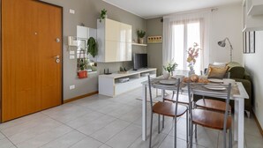 A modern kitchen with a dining area, a wooden door, a white cabinet, and a television. - ChatGPT ha detto:The SpaceWelcome to your corner of tranquility at the gateway to Venice!This cozy apartment in Mestre is the ideal solution for those who want to enjoy Venice stress-free, thanks to its strategic location in a quiet, safe, and well-serve (Venice)