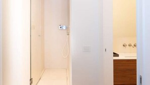 Een douche, een bidet, handdoeken, shampoo